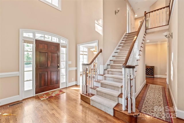 entryway featuring a high ceiling, a healthy amount of sunlight, and stairway
