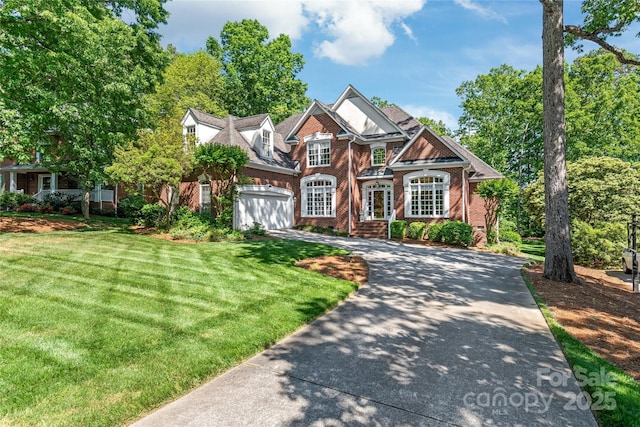 view of front of home featuring an attached garage, concrete driveway, a front lawn, and brick siding