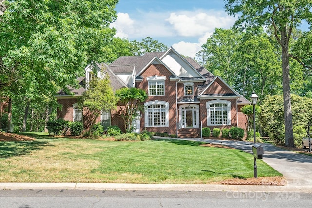 view of front facade featuring brick siding and a front lawn