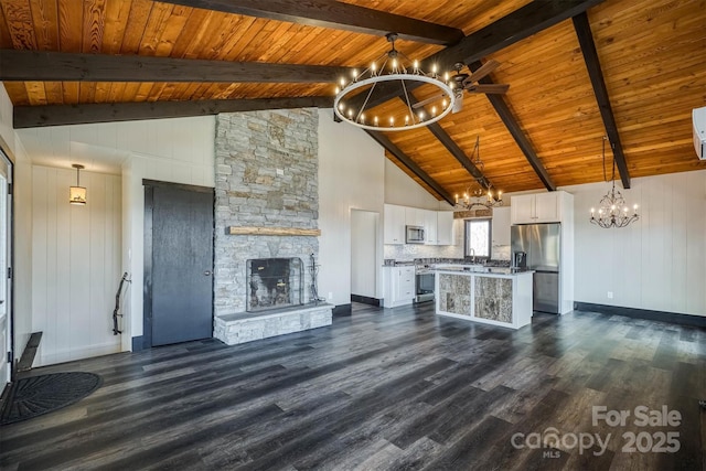 unfurnished living room with high vaulted ceiling, an inviting chandelier, and dark wood-type flooring
