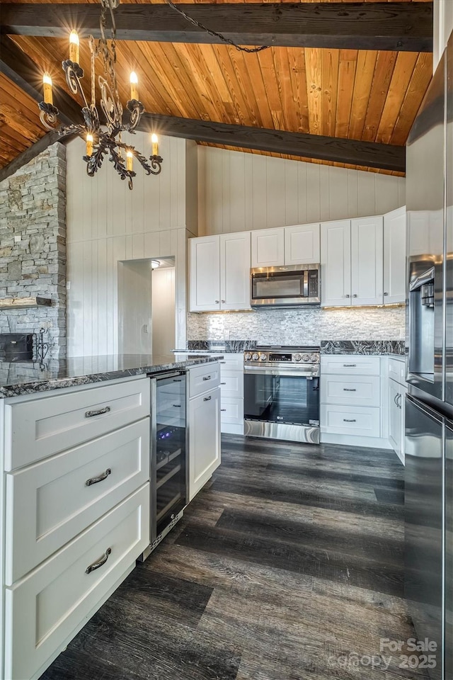 kitchen featuring appliances with stainless steel finishes, lofted ceiling with beams, wooden ceiling, and wine cooler