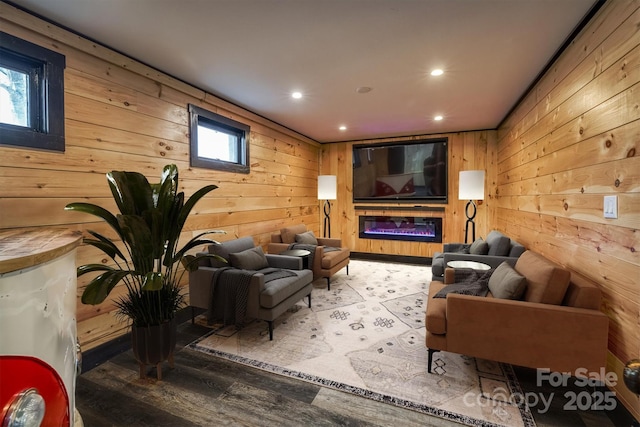 living room featuring wooden walls, recessed lighting, plenty of natural light, and wood finished floors