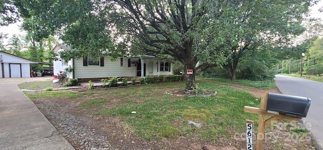 view of property hidden behind natural elements with a detached garage and an outdoor structure