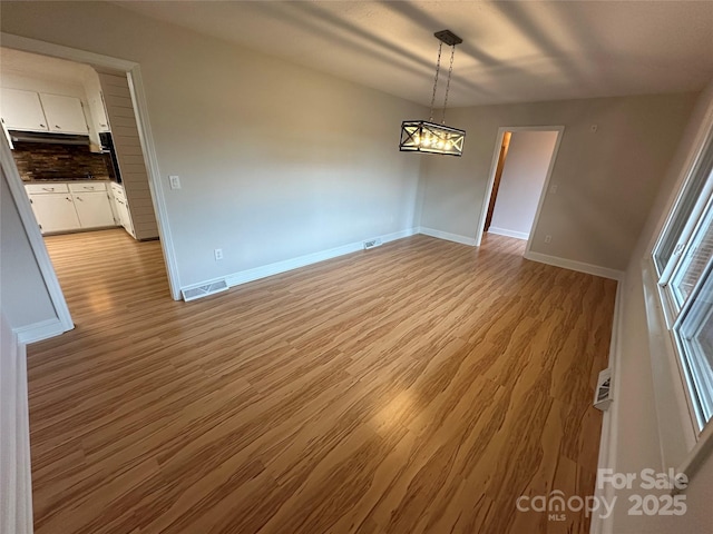 396 Pitts School Rd NW, Concord, NC 28027 - unfurnished dining area with light wood-style floors and baseboards