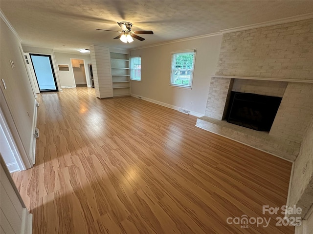 396 Pitts School Rd NW, Concord, NC 28027 - unfurnished living room featuring a fireplace, crown molding, a ceiling fan, light wood finished floors, and built in shelves