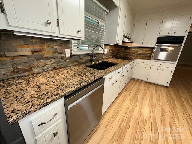 396 Pitts School Rd NW, Concord, NC 28027 - kitchen with appliances with stainless steel finishes, light wood finished floors, white cabinets, dark stone countertops, and decorative backsplash