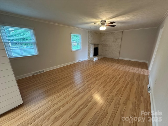 396 Pitts School Rd NW, Concord, NC 28027 - unfurnished living room featuring a ceiling fan, light wood-type flooring, a fireplace, and crown molding