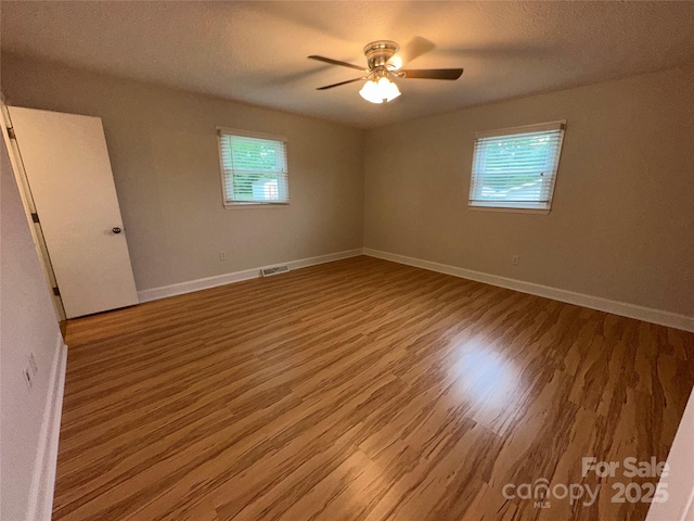 396 Pitts School Rd NW, Concord, NC 28027 - spare room featuring plenty of natural light, wood finished floors, and a ceiling fan