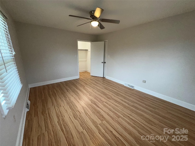396 Pitts School Rd NW, Concord, NC 28027 - spare room with wood finished floors, a ceiling fan, and healthy amount of natural light