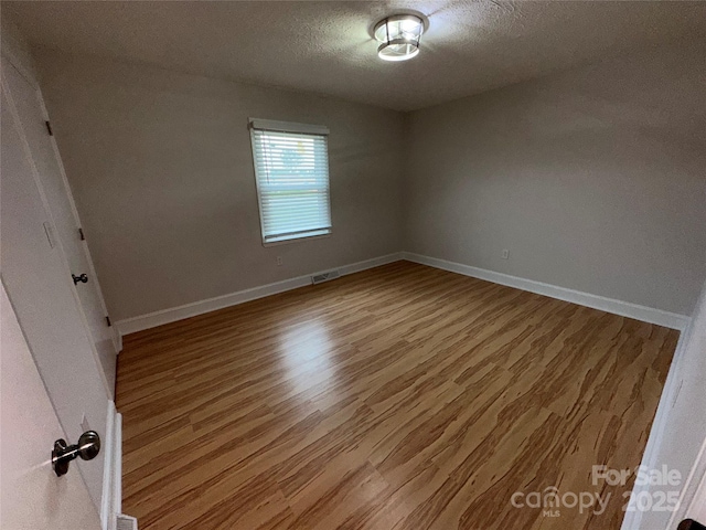 396 Pitts School Rd NW, Concord, NC 28027 - empty room with wood finished floors and a textured ceiling