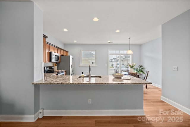 233 E Waterlynn Rd Unit B, Mooresville, NC 28117 - kitchen featuring stainless steel appliances, brown cabinets, light wood-style flooring, light stone counters, and recessed lighting
