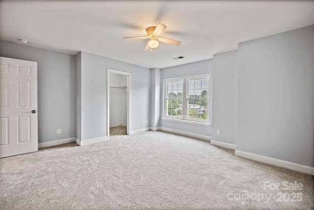 233 E Waterlynn Rd Unit B, Mooresville, NC 28117 - unfurnished bedroom featuring carpet floors, a walk in closet, and ceiling fan