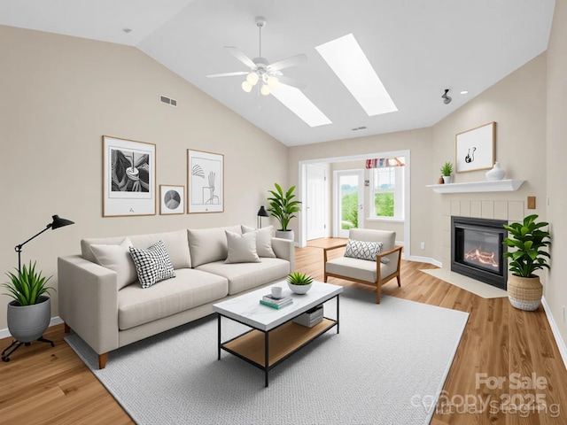 5802 Wood Duck Way, Hendersonville, NC 28792 - living area featuring vaulted ceiling, light wood-style floors, a skylight, a fireplace, and baseboards