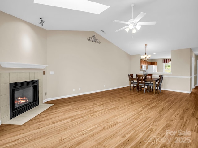 5802 Wood Duck Way, Hendersonville, NC 28792 - living area featuring lofted ceiling, a tile fireplace, light wood-type flooring, a skylight, and baseboards