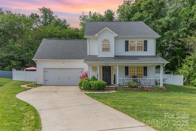 traditional-style home featuring fence, an attached garage, a front lawn, a porch, and concrete driveway