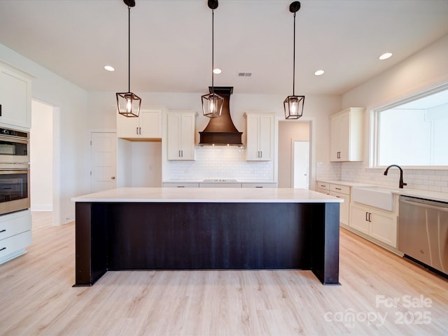 1706 Ruben Rd, Monroe, NC 28112 - kitchen featuring decorative backsplash, custom range hood, appliances with stainless steel finishes, light countertops, and a sink
