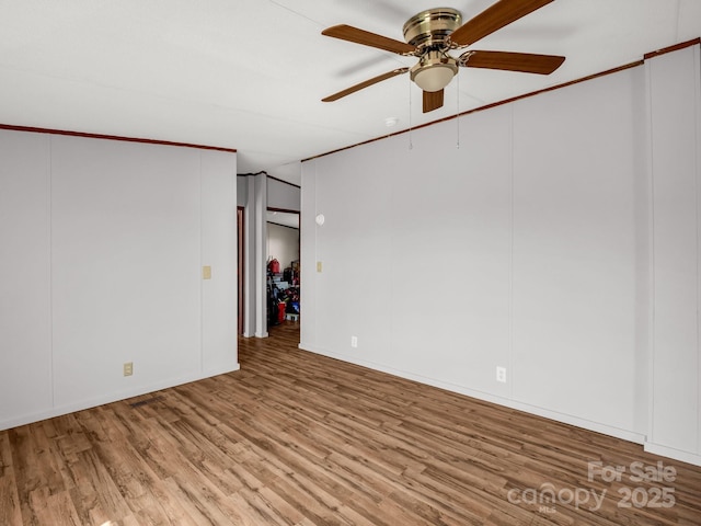empty room featuring a ceiling fan and wood finished floors