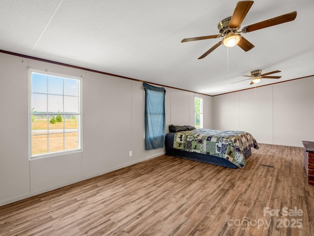 bedroom featuring crown molding, a ceiling fan, and wood finished floors