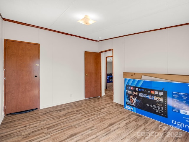 empty room with ornamental molding and wood finished floors