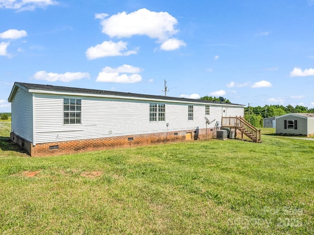 back of property featuring central air condition unit, crawl space, a yard, and stairway