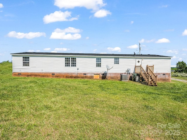 rear view of house featuring a lawn, central AC unit, and crawl space