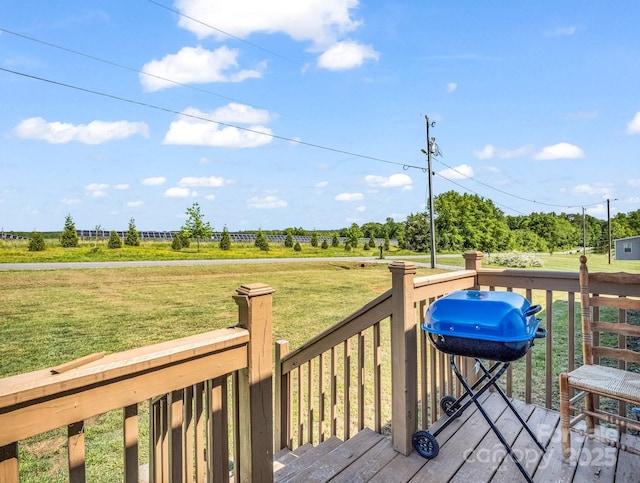 wooden terrace featuring a yard and a grill