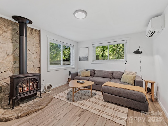 24 Iroquois St, Black Mountain, NC 28711 - living area with a wood stove, an AC wall unit, plenty of natural light, and light wood finished floors