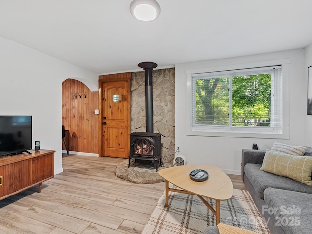 24 Iroquois St, Black Mountain, NC 28711 - living room with light wood-type flooring, a wood stove, arched walkways, and baseboards