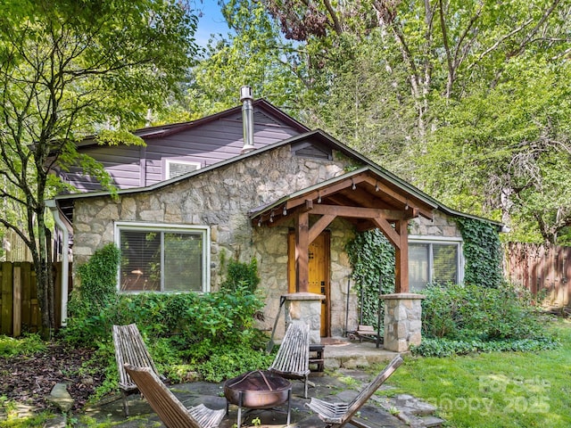 24 Iroquois St, Black Mountain, NC 28711 - mid-century home with stone siding, a fire pit, and fence