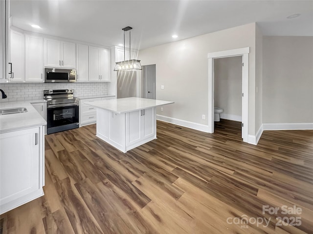 420 Fulton Dr, Kings Mountain, NC 28086 - kitchen featuring appliances with stainless steel finishes, a sink, white cabinets, baseboards, and light countertops