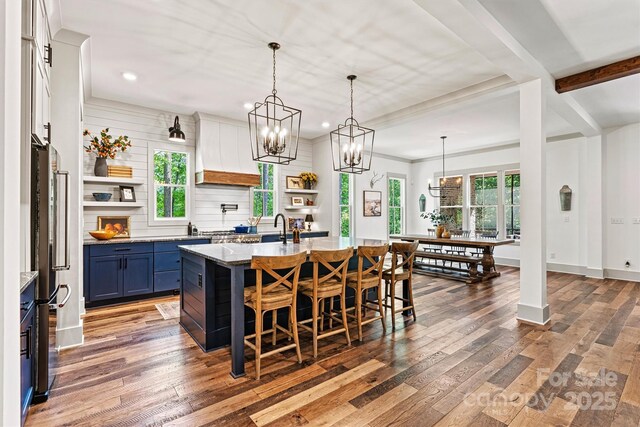 kitchen featuring open shelves, a breakfast bar, recessed lighting, custom exhaust hood, and blue cabinets