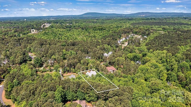 birds eye view of property featuring a view of trees