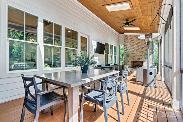deck with a fireplace, a ceiling fan, and outdoor dining area
