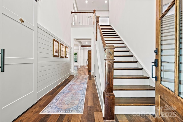 interior space featuring stairs, a high ceiling, and hardwood / wood-style flooring