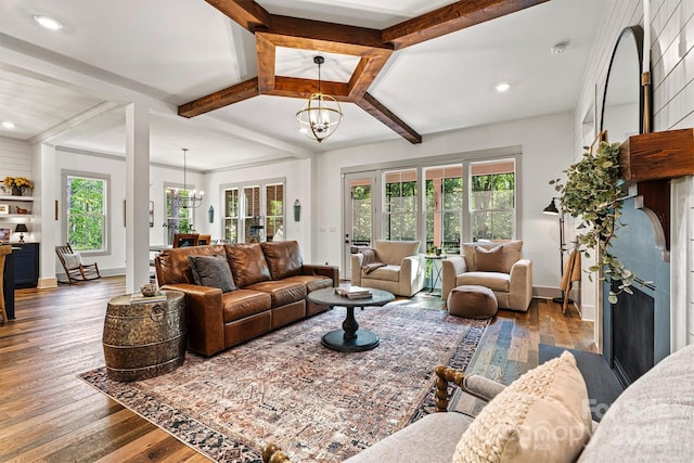 living area with plenty of natural light, hardwood / wood-style floors, and a chandelier