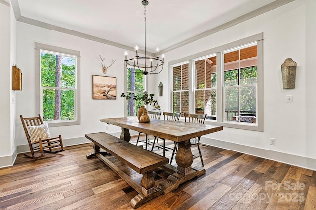 dining space with an inviting chandelier, baseboards, and dark wood-type flooring