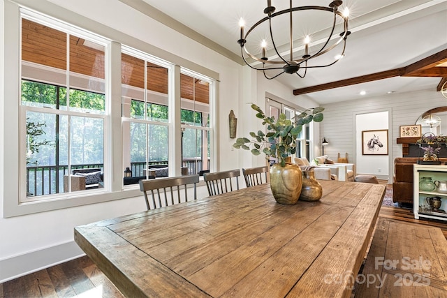 dining area featuring beamed ceiling, baseboards, dark wood finished floors, and an inviting chandelier