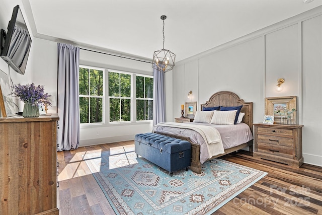bedroom featuring baseboards, visible vents, wood-type flooring, and a chandelier