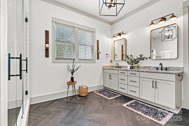 bathroom featuring double vanity, a sink, baseboards, and a chandelier