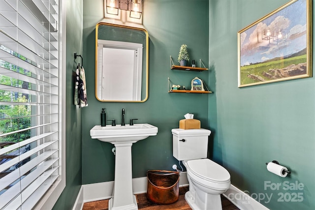 bathroom featuring baseboards and toilet