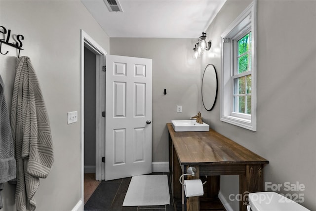 bathroom with visible vents, baseboards, tile patterned floors, and vanity