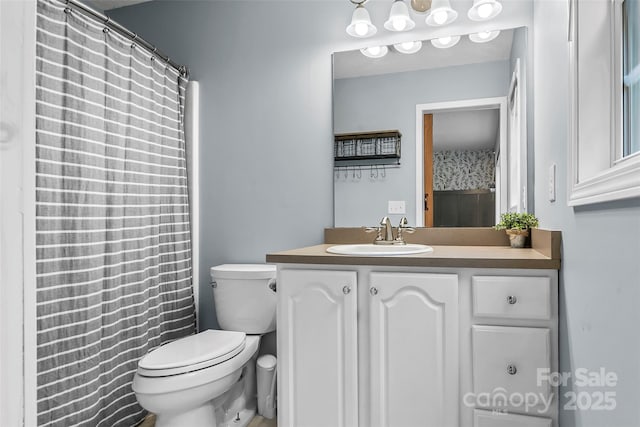 bathroom featuring toilet, a shower with shower curtain, and vanity