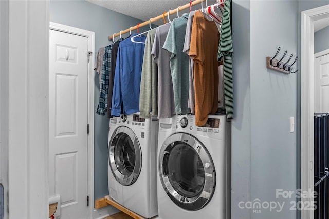 laundry room with laundry area, a textured ceiling, and washing machine and clothes dryer
