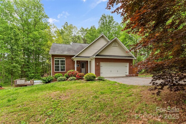view of front of property featuring a garage, aphalt driveway, a front yard, roof with shingles, and brick siding