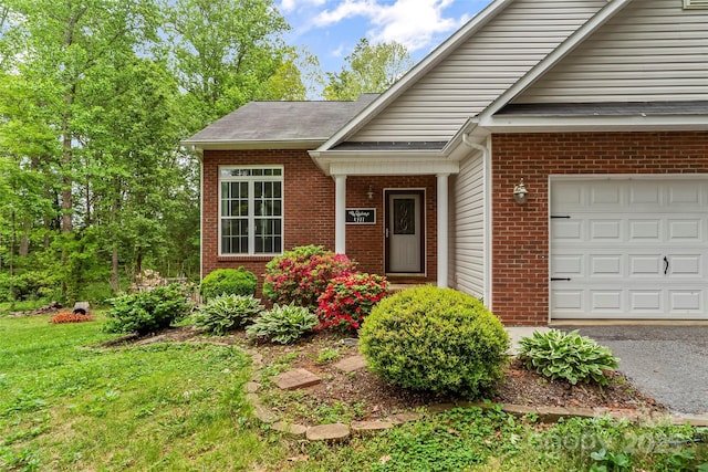 property entrance with brick siding and an attached garage