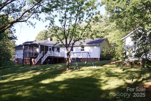 854 Silver Fox Dr, Concord, NC 28025 - rear view of property with a sunroom, a playground, a lawn, and a chimney