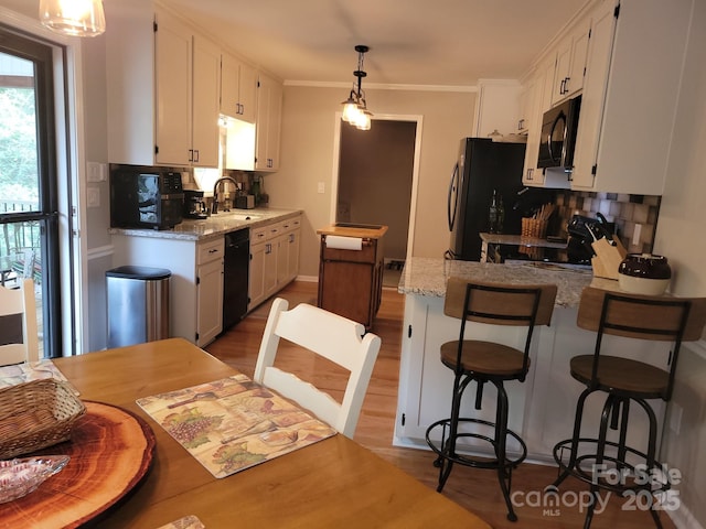 854 Silver Fox Dr, Concord, NC 28025 - kitchen featuring a sink, black appliances, white cabinets, tasteful backsplash, and a peninsula