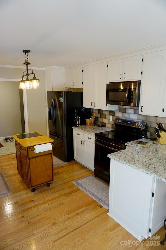 854 Silver Fox Dr, Concord, NC 28025 - kitchen featuring black appliances, white cabinets, light wood-style flooring, tasteful backsplash, and pendant lighting