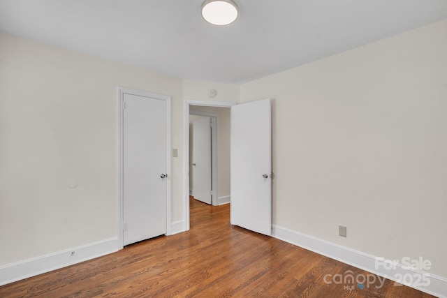 spare room with wood finished floors and baseboards