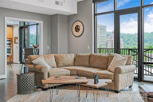 living room with a wealth of natural light, wood finished floors, and visible vents